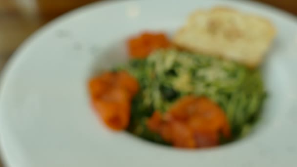 Espaguetis pesto con salmón en plato blanco — Vídeo de stock