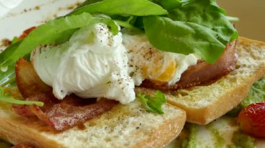 sahanda yumurta ve yeşilliklerle altında pastırmalı tost