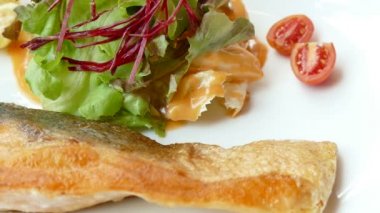 Balık parça salata ve domates plaka üzerinde