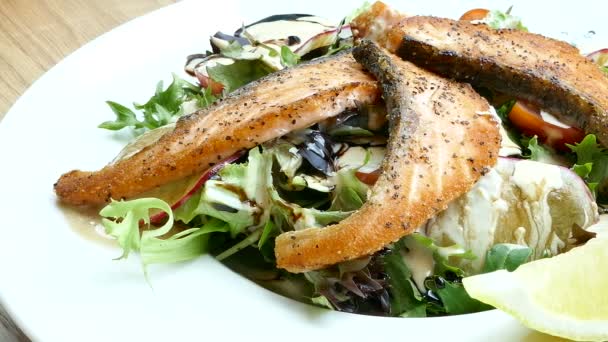 Pedaços de peixe com salada e limões — Vídeo de Stock