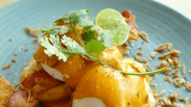 lezzetli Yumurta Benedict beyaz tabak içinde pastırma ile 