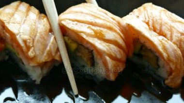 lezzetli taze suşi alarak bambu çubuklarla, geleneksel Japon yemekleri rulo 