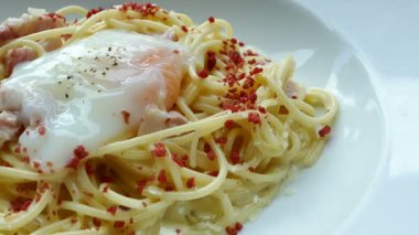 leziz spagetti carbonara beyaz tabak içinde gevrek domuz pastırması ile 