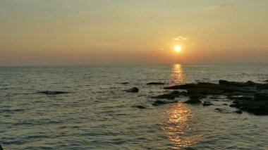 dalgalar deniz, kumsal ve dramatik gökyüzü günbatımı görünümünü