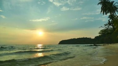 dalgalar deniz, kumsal ve dramatik gökyüzü günbatımı görünümünü