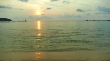 dalgalar deniz, kumsal ve dramatik gökyüzü günbatımı görünümünü