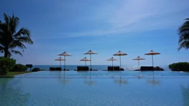 Güneş şemsiyeleri ve deniz ve havuz manzarası
