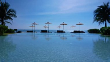 Güneş şemsiyeleri ve deniz ve havuz manzarası