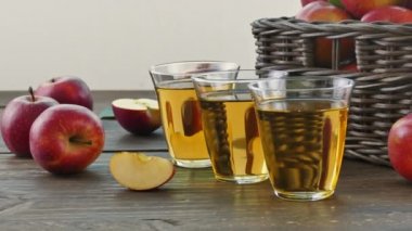 Tahta kutuda taze elma yığını ve bir bardak meyve suyu.