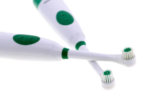 Elektronische Zahnbürste mit isolierten Zahnbürstenköpfen auf grünem Untergrund — Stockfoto