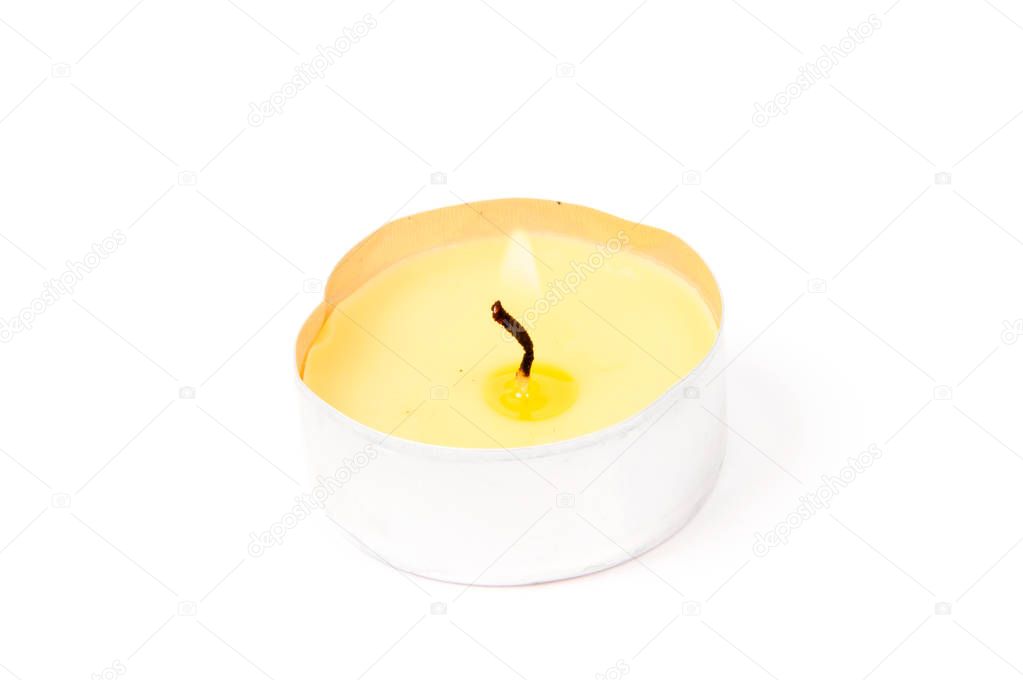 A burning candle isolated on white background with light shaddow and reflection
