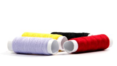 Beyaz arkaplanda izole edilmiş renkli iplik makaraları