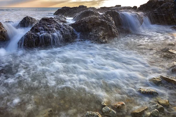Agua de mar que fluye sobre las rocas — Foto de Stock