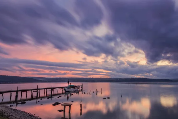Excitante puesta de sol en un lago con puente y barco  . — Foto de Stock