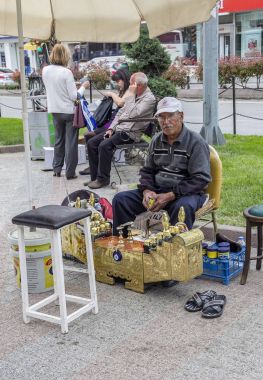 Edirne, Türkiye, 02,2015 olabilir. Şehirdeki sokak Ayakkabı temizleme. Kentsel park iş yerinde oturan ve bir müşteri bekleyen Türk iş adamı