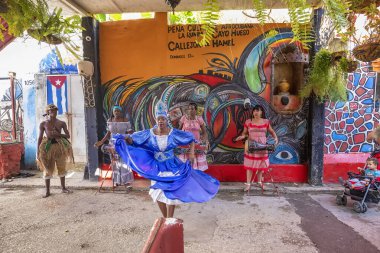 Havana, Cuba - December 20, 2019: Cuban young people dance with typical dresses for tourists in the Callejon de Hamel clipart