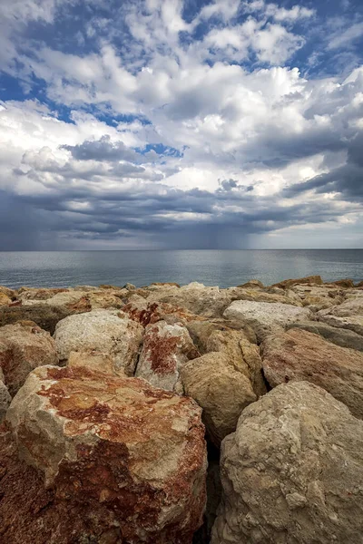 Kleurrijke Stenen Een Oever Met Stormachtige Wolken Aan Horizon Verticaal — Stockfoto
