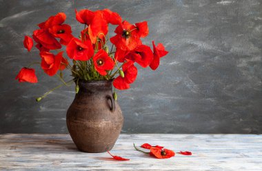 Natürmort rustik tarzda: eski bir sakat ve kırmızı haşhaş ahşap bir masa üzerinde bir buket