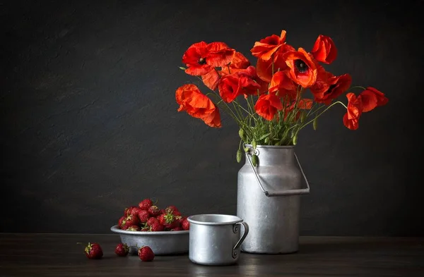 Stilleben im rustikalen Stil: Aluminiumplatte und Dose, Strauß roter Mohn und Erdbeere auf einem Holztisch. — Stockfoto