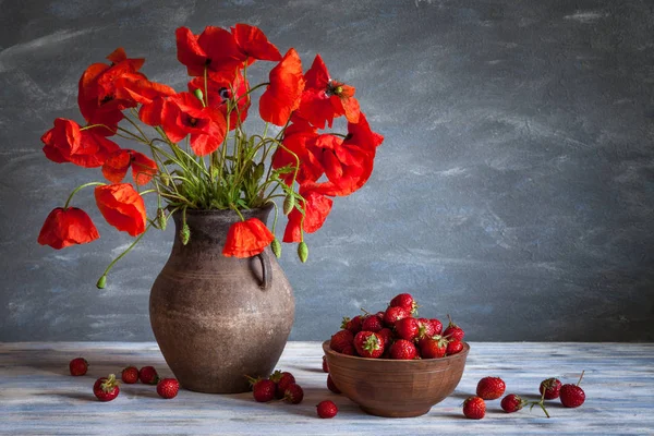 Still life in a rustic style: pottery and a bouquet of red poppies