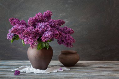 Still Life: Ahşap bir masa üzerinde bir demet leylak ve çömlek.