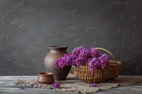 Ein Strauß Flieder Weidenkorb Und Keramik Auf Einem Holztisch Stillleben — Stockfoto