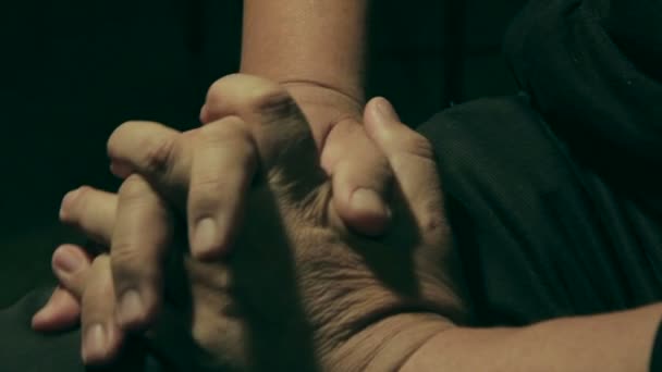 Een oudere man probeert te herstellen van gevoel aan zijn gevoelloos hand — Stockvideo