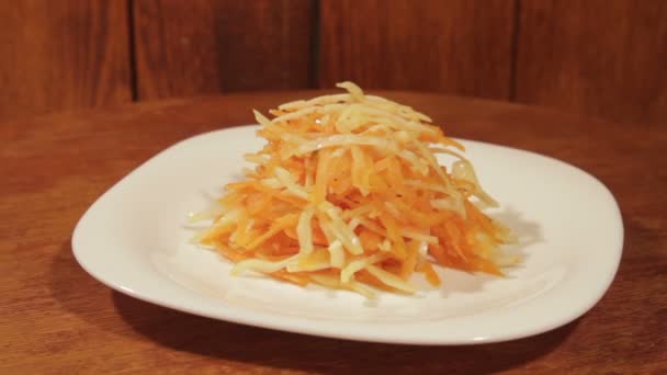 Insalata vegetale di carota e cavolo in piatto bianco su sfondo di legno da vicino. Insalata sana vegetariana in olio vegetale — Video Stock
