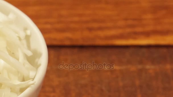 Col picada en taza blanca sobre fondo de madera de cerca. Ingrediente para ensalada de verduras — Vídeo de stock