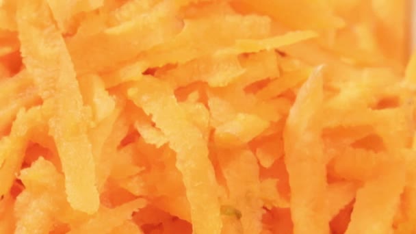 Zanahoria picada en taza blanca sobre fondo de madera de cerca. Ingrediente para ensalada de verduras — Vídeo de stock