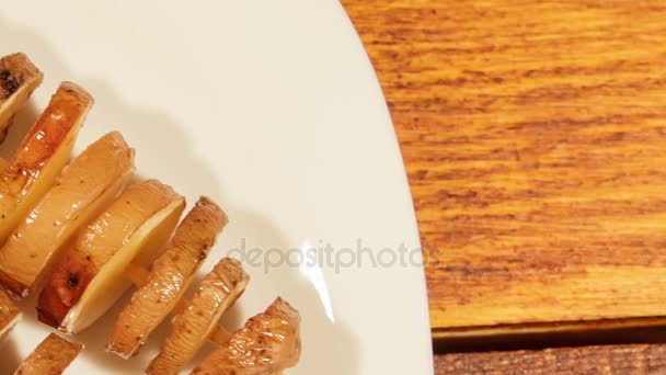 Brochetas de patata, horneadas en el horno, sobre el plato blanco . — Vídeo de stock