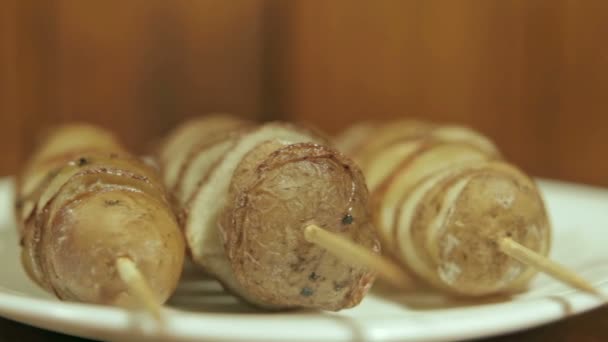 Spiesjes van aardappel, gebakken in de oven, op de witte plaat. — Stockvideo