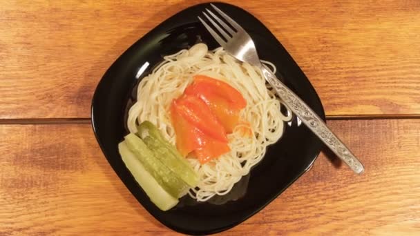Итальянская паста с овощным соусом и маринованным огурцом на деревянном фоне — стоковое видео