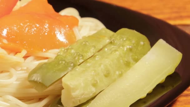 Italiaanse pasta met groente saus en ingemaakte komkommer op een houten achtergrond — Stockvideo