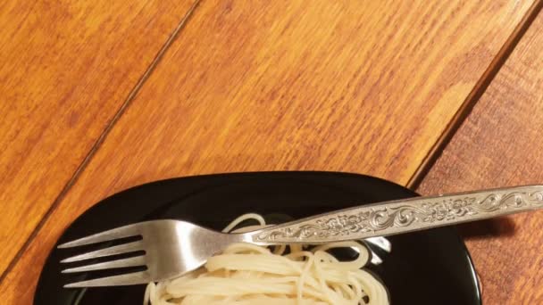 Italian pasta with vegetable sauce and pickled cucumber on a wooden background — Stock Video