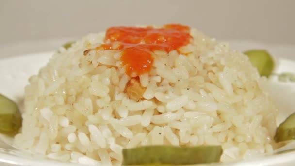 Rotating dish of rice with marinaded cucumbers. — Stock Video