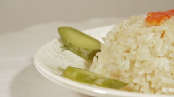 Rotating dish of rice with marinaded cucumbers. — Stock Video