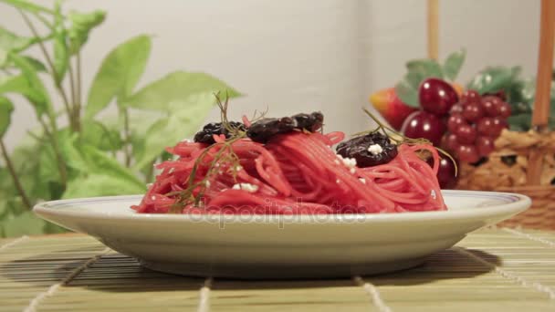 Vegetariánské těstoviny s omáčkou z červené řepy, švestek a sýrem. — Stock video