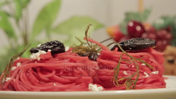 Vegetariánské těstoviny s omáčkou z červené řepy, švestek a sýrem. — Stock video