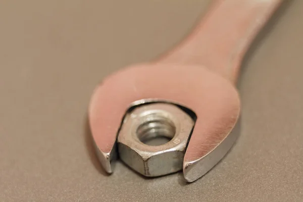 Metal nut And Chrome-Vanadium Spanner Gripping Isolated On blurred Background — Stock Photo, Image