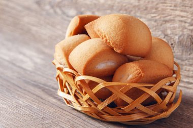 Burnunuzdaki ahşap arka plan üzerinde hasır sepet içinde taze kurabiye ev yapımı kahvaltı. Rustik konsepti