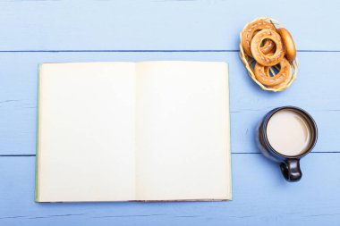 Kahve süt ve ahşap masa boş sayfa ile açık kitap. Hafif kahvaltı ve eğitim