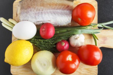 Gıda maddeleri çeşitli sebze, yumurta ve balık portre üzerinde sağlıklı dengeli yemek için. Taze organik domates, zengin vitamin turp ve sarımsak. Üstten Görünüm