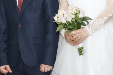 Gelin ve Damat Düğün töreni üzerinde. Kadının elinde gül buketi. Güzel gelinlik ve zarif kostüm