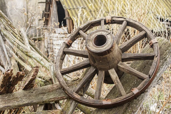 Old wooden wheel on background of ruins of old farm. Copy space — Stock Photo, Image