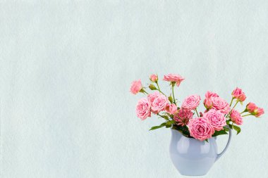 Suluboya mavi boyalı arka plan üzerinde mavi sürahi içinde pembe çiçekler. 