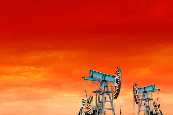Oil pumps at sunset. Orange sky.