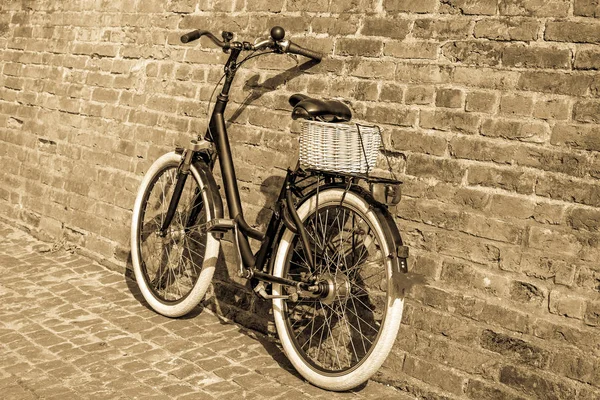 Bicicleta vintage retro preto com parede de tijolo velho . — Fotografia de Stock