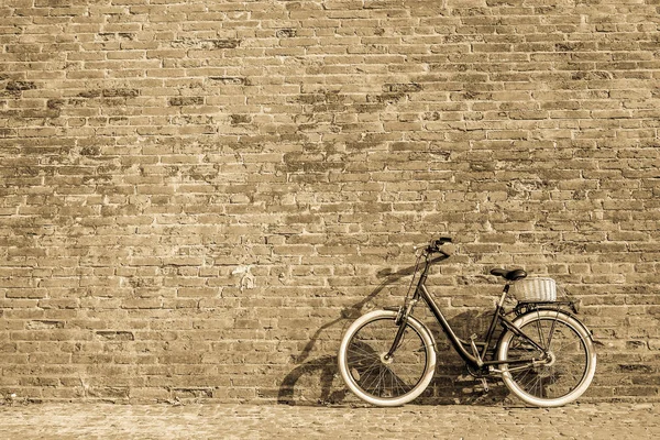 Black retro vintage bicycle with old brick wall.