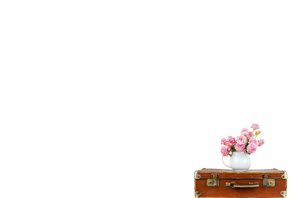 Pink flowers in jug on old brown vintage suitcase. Roses in jug. Pink roses. Shabby chic. Rustic concept. — Stock Photo, Image